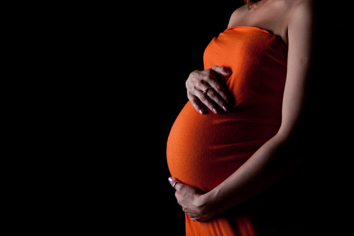 Pregnant woman against a black background