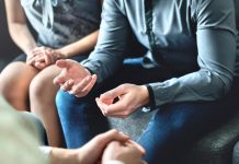 Close up photograph of man and woman sat next to each other at talking therapy session