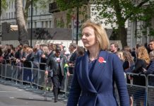 UK Prime Minister Liz Truss walking along wearing navy suit