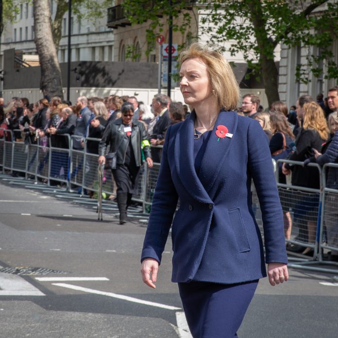UK Prime Minister Liz Truss walking along wearing navy suit