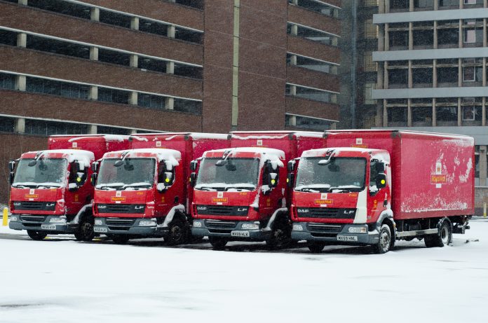Royal Mail trucks lined up covered in snow