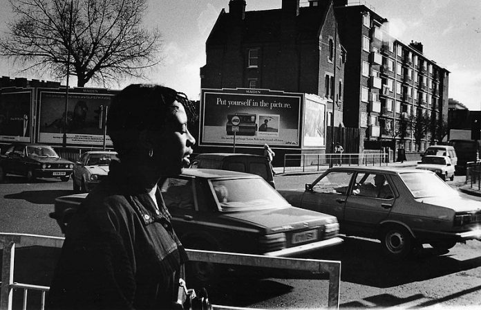 Brenda Agard, Black British photographer on a photo shoot in London, 1987. Agard was instructing students on street photography. The workshop was part of the educational programming for the exhibit "Testimony: Three Blackwomen Photographers: Brenda Agard, Ingrid Pollard, Maud Sulter" at Camerawork London.
