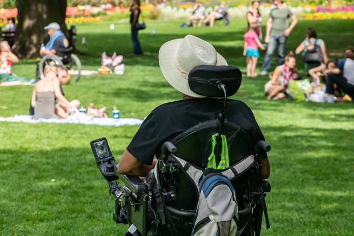 Rear view of disabled man sitting on wheelchair