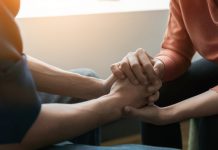 Mental health concept, Psychologist sitting and touch hand young depressed man for encouragement