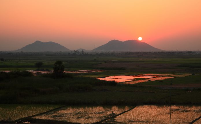 Beautiful sunset in the area of Nalgonda, India in Andhra Pradesh - reflecting in rice patties below.