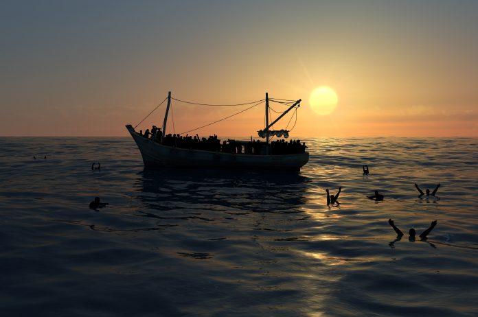 Refugees in boat on sea against sunset or sunrise