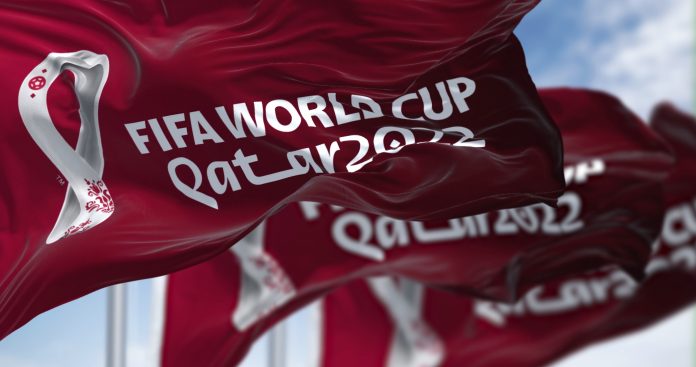 Three flags with the Qatar 2022 Fifa World Cup logo waving in the wind