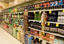 UK supermarket aisle full of shelves of fizzy drinks high in sugar