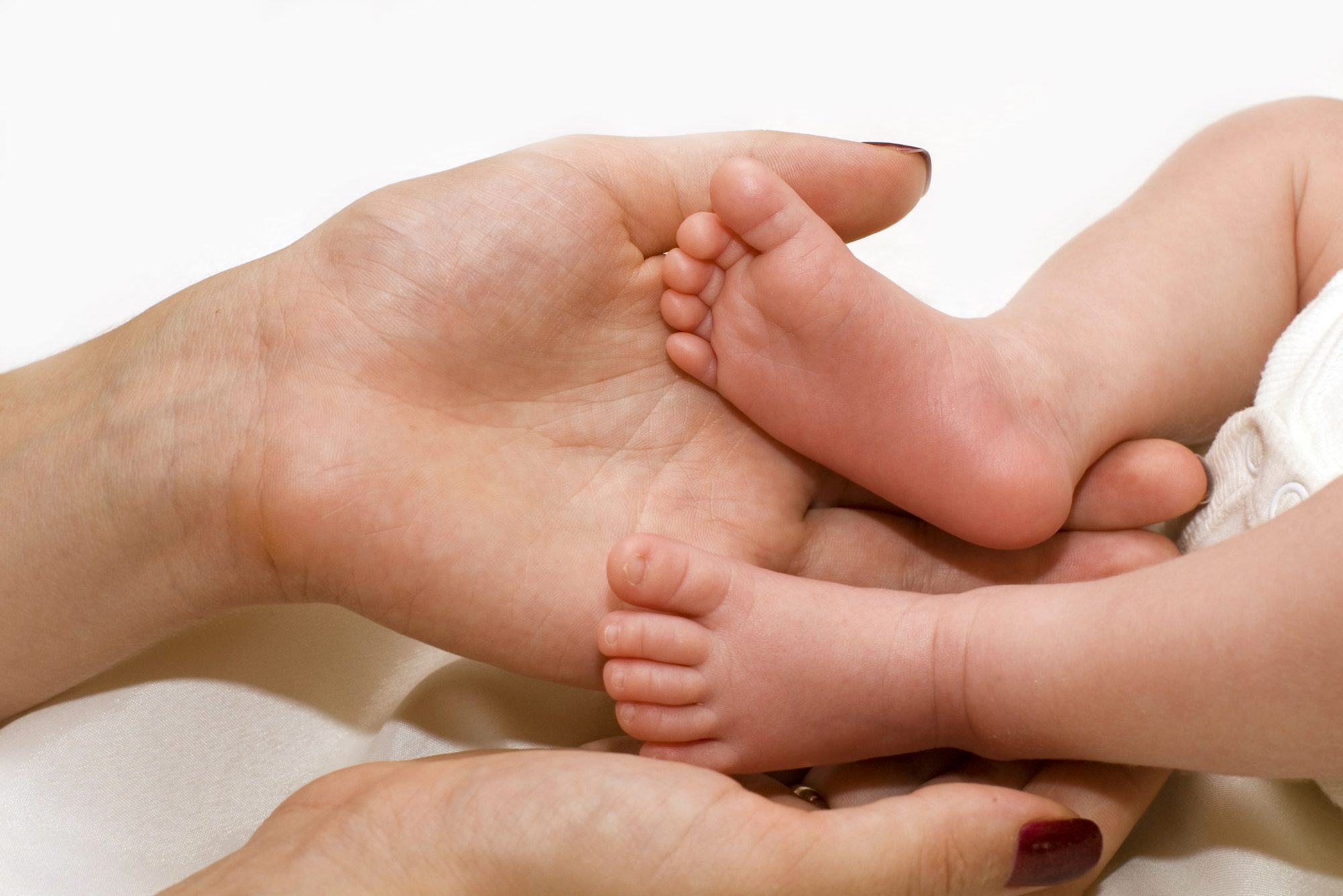 Mother's hand touching baby's feet