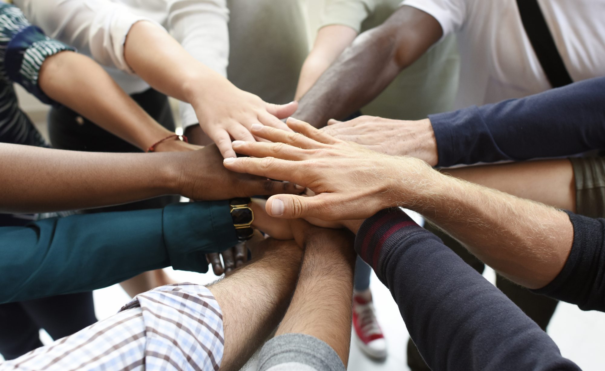 Group of business people putting hands together in circle