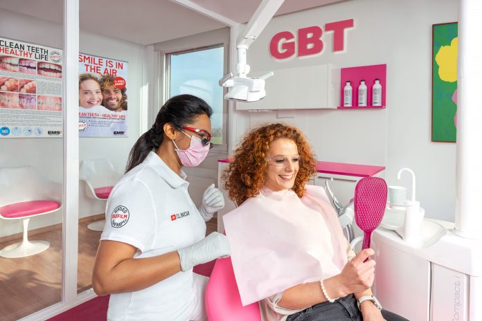 dentist and patient sat in chair looking in mirror