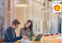 How to reduce operational costs while accelerating decarbonisation of fleets with Sheel Fleet Solutions - two people sat at desk on laptop working at Shell Fleet Solutions discussing strategy