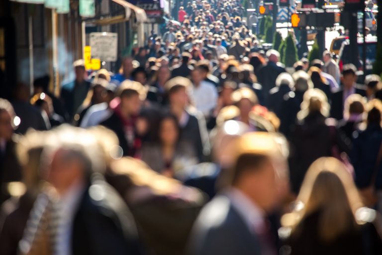 Crowd of people walking on city street to work