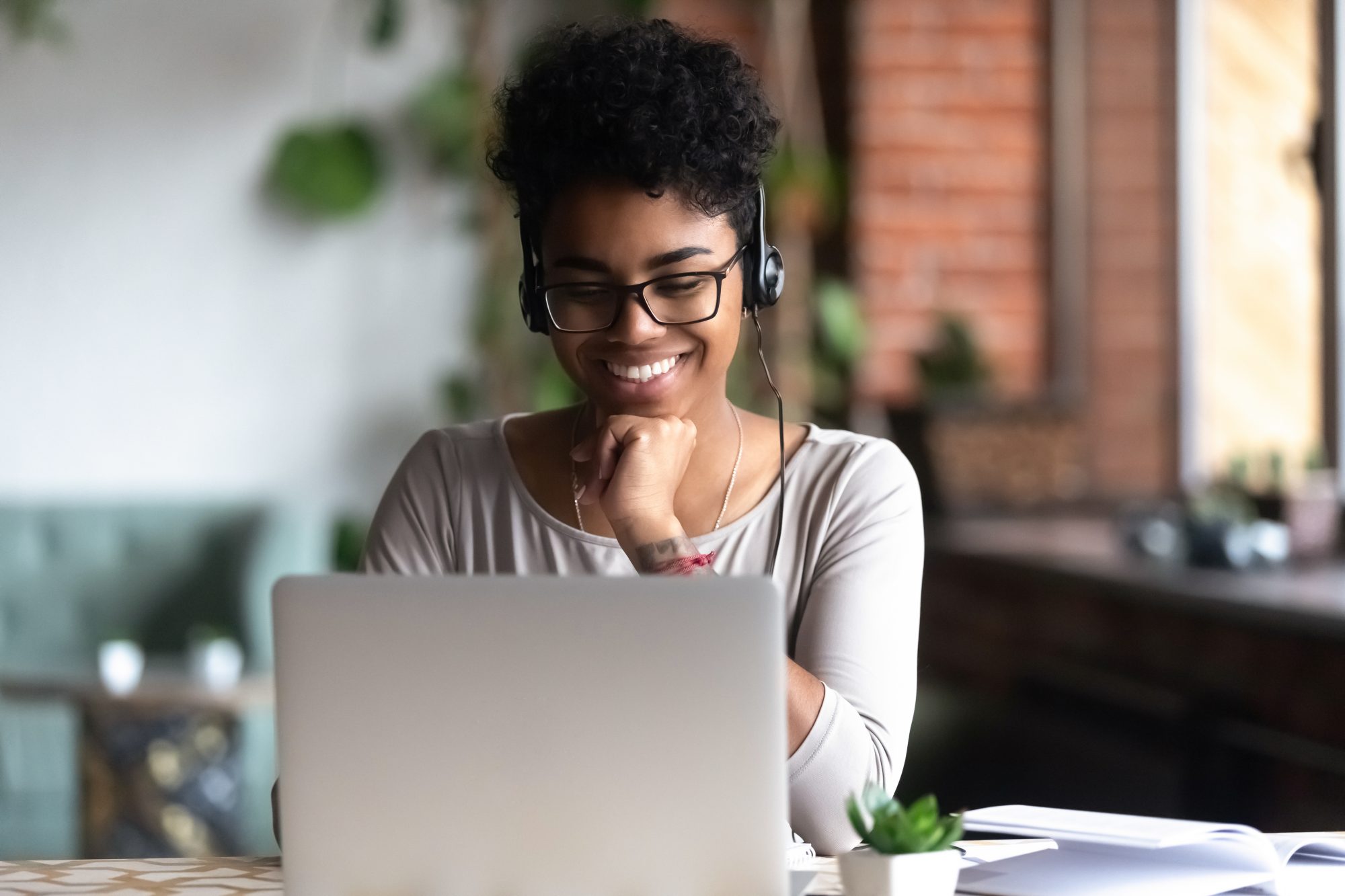 Woman sat in front of laptop doing her work with headphones in