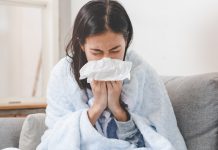 Woman with cold blowing nose