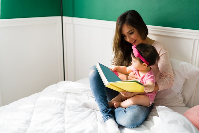 mom reading a children`s book to baby