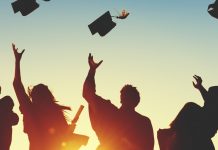 Silhouette of graduates throwing their caps up in the air against a beautiful sunset sky