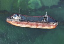 The old rusty ship was stranded by a storm. Oil spill from a tanker, environmental pollution