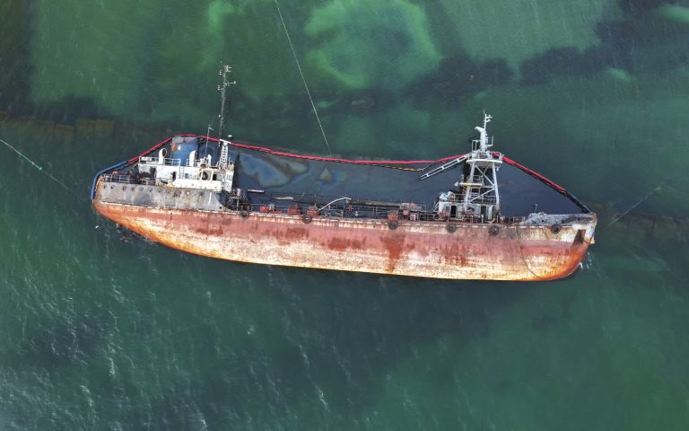 The old rusty ship was stranded by a storm. Oil spill from a tanker, environmental pollution