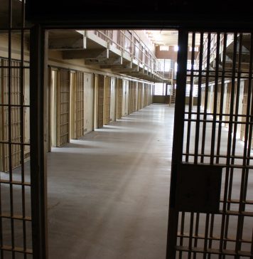 A multi-tiered cellblock is seen from the prison guard secured area