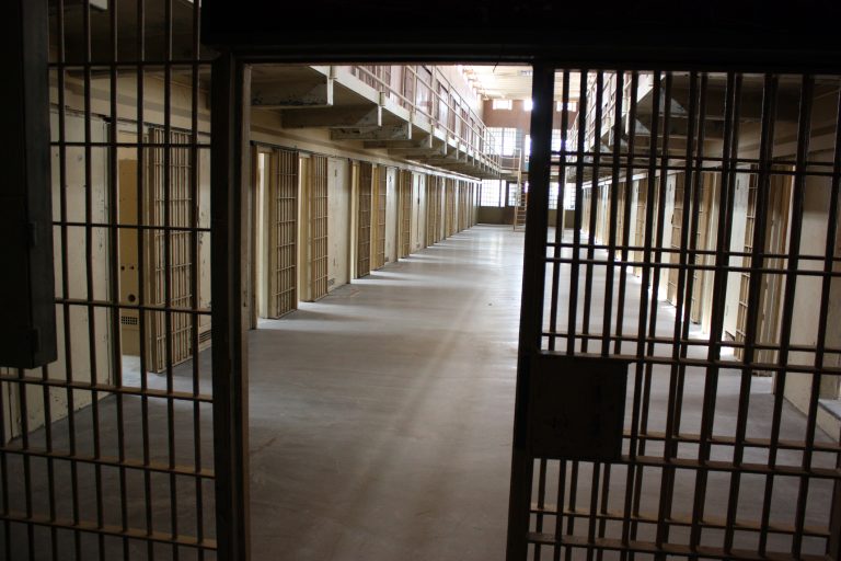 A multi-tiered cellblock is seen from the prison guard secured area