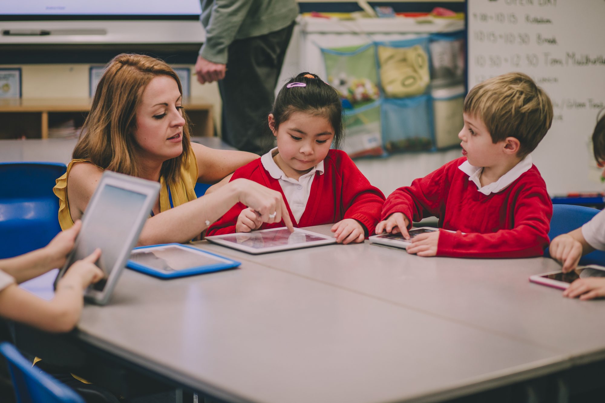 Group of students in a primary school are having a digital tablet lesson with their teacher.