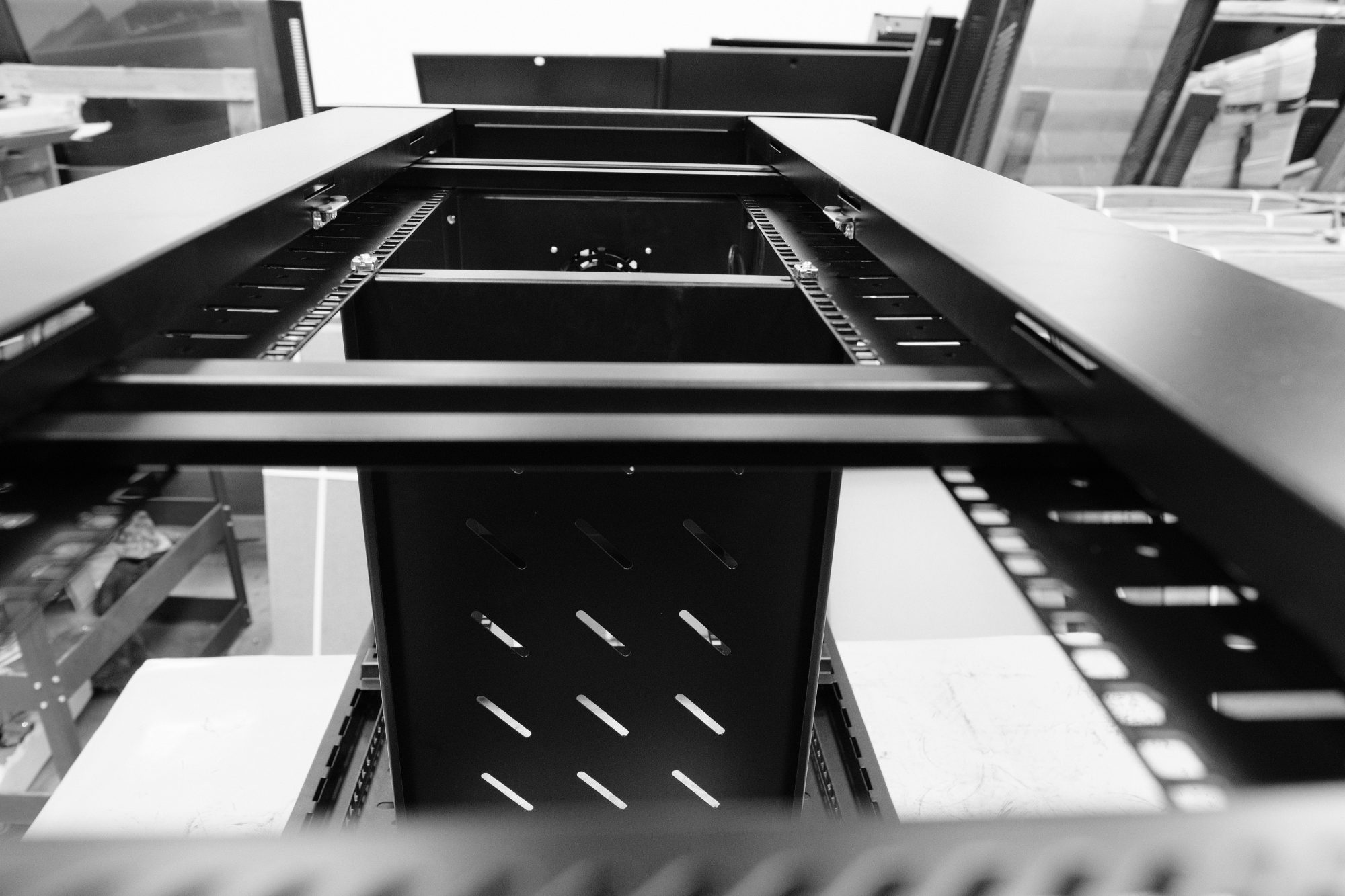 Data and networking communications cabinets and enclosures being assembled from there component parts. These floor standing cabinets will be used in data centres and server farms