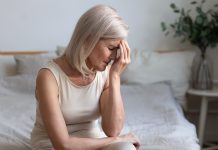 menopause leave blocked by parliament, middle aged women sad on bed looking concerned