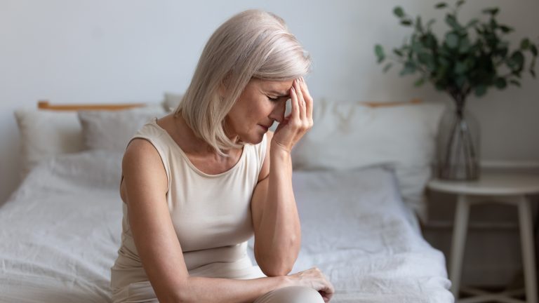 menopause leave blocked by parliament, middle aged women sad on bed looking concerned