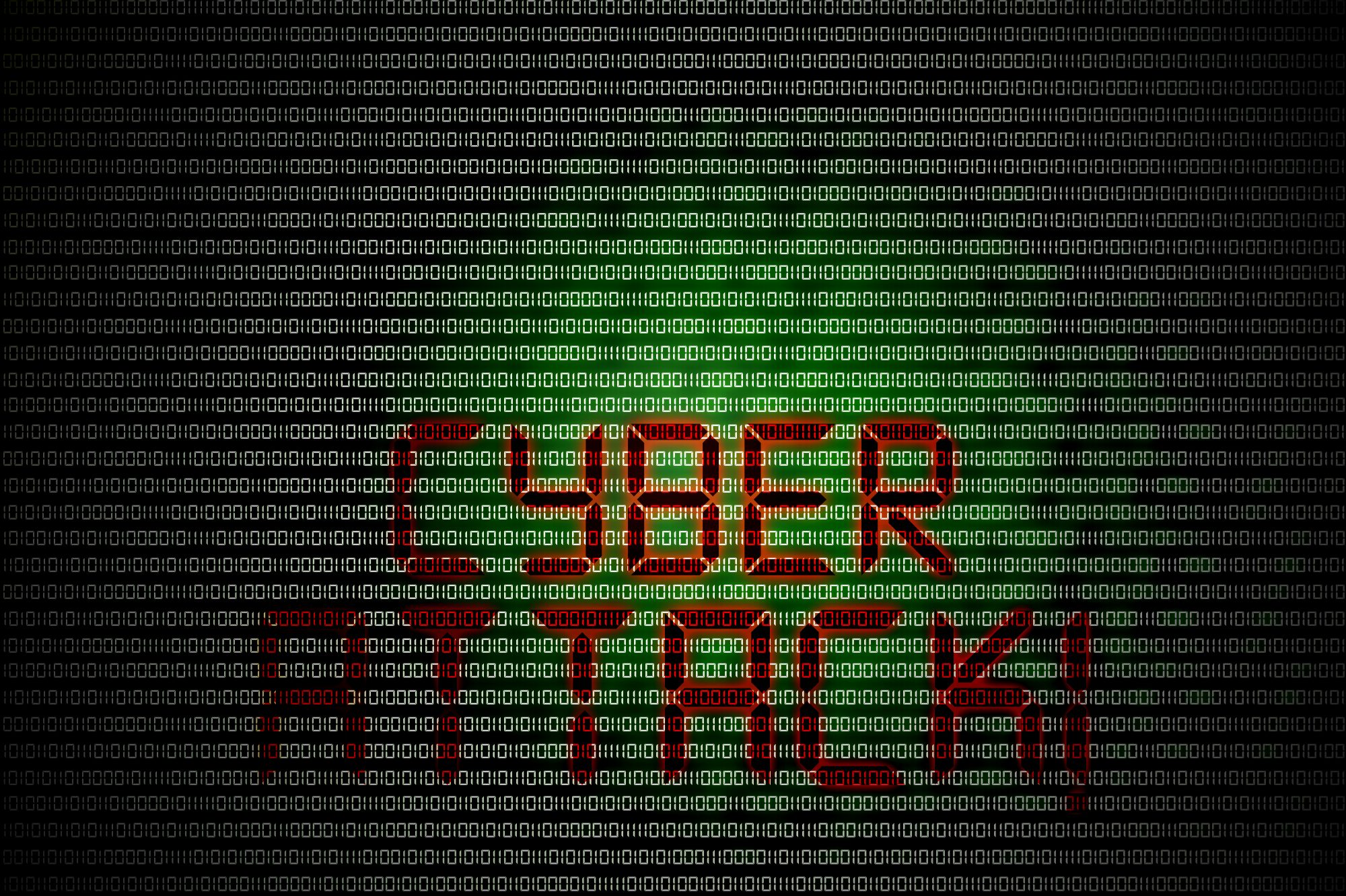 Cyber attack written on a computer screen with 1s and 0s.