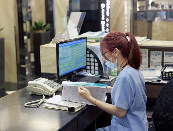 woman working on an EHR in a hospital