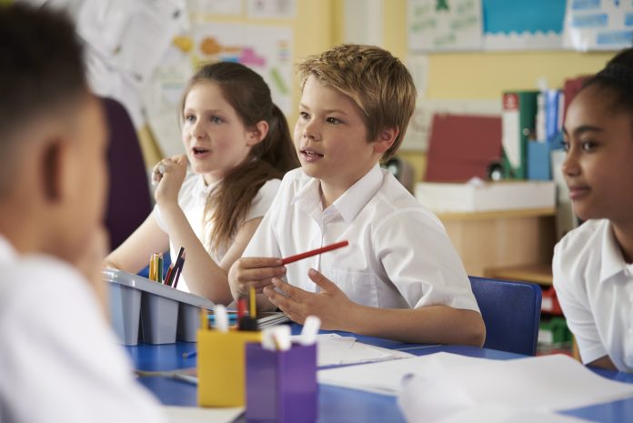 Primary school children work together in class, close up