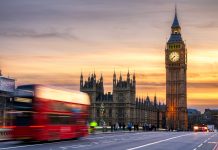 London, the UK. Red bus in motion and Big Ben,