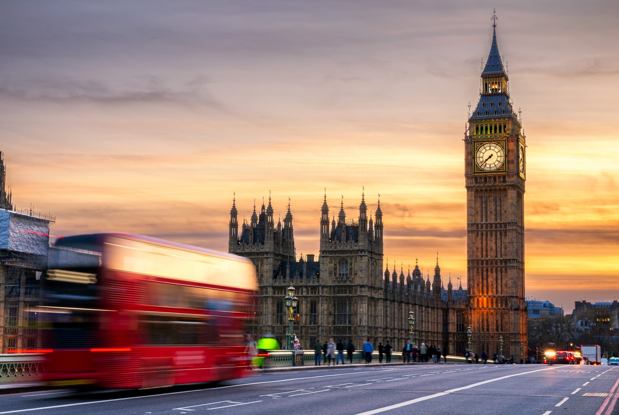 London, the UK. Red bus in motion and Big Ben,