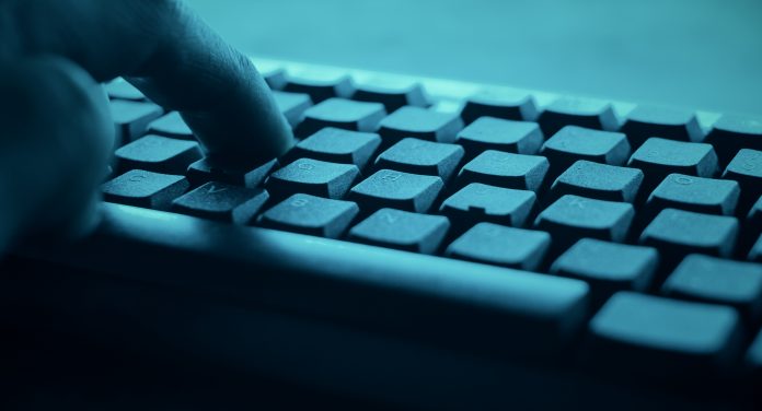 Hands typing on pc desktop computer keyboard. Cyber hacker attack concept.