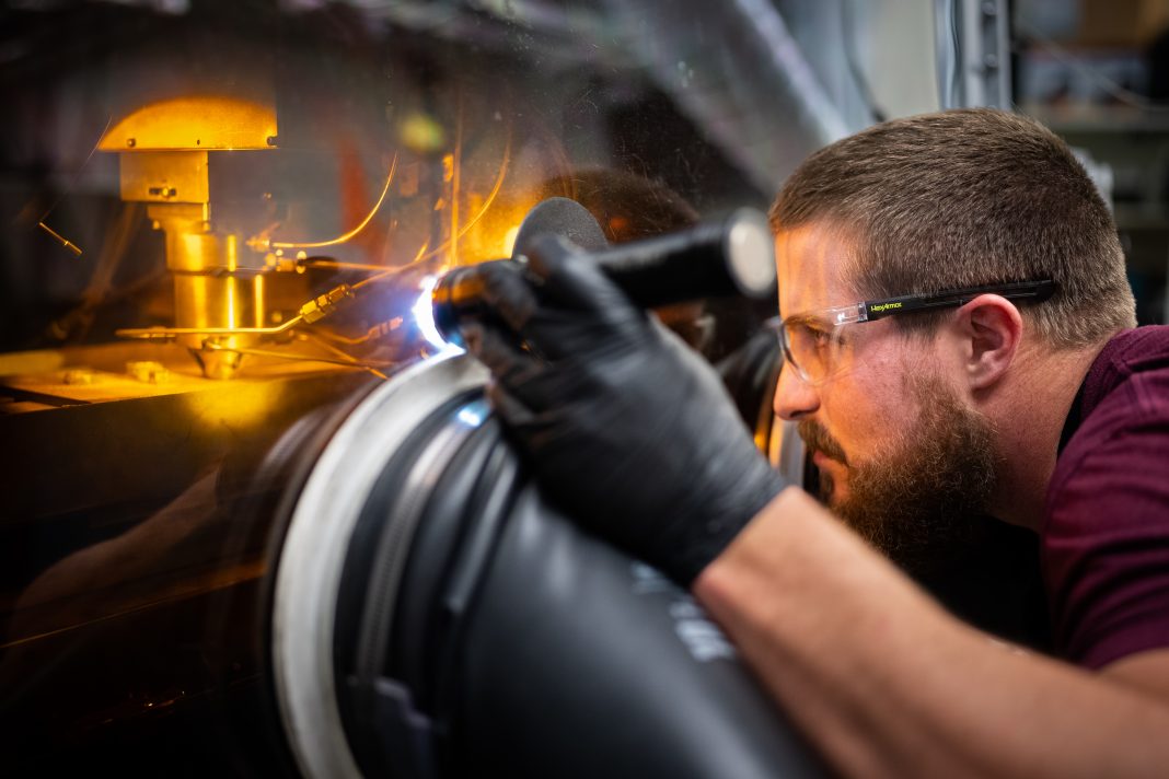Levi Van Bastian works to print material on the LENS machine on Dec. 21, 2022, allowing the ability to test 3D print new superalloys.