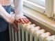 woman touching radiator indicating energy crisis problems