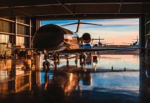 Servicing business aviation at a hangar in backlight at sunset