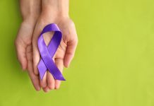 Woman holding purple ribbon on color background. Pancreatic cancer awareness concept