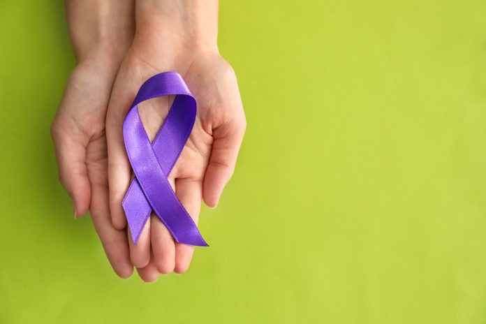 Woman holding purple ribbon on color background. Pancreatic cancer awareness concept