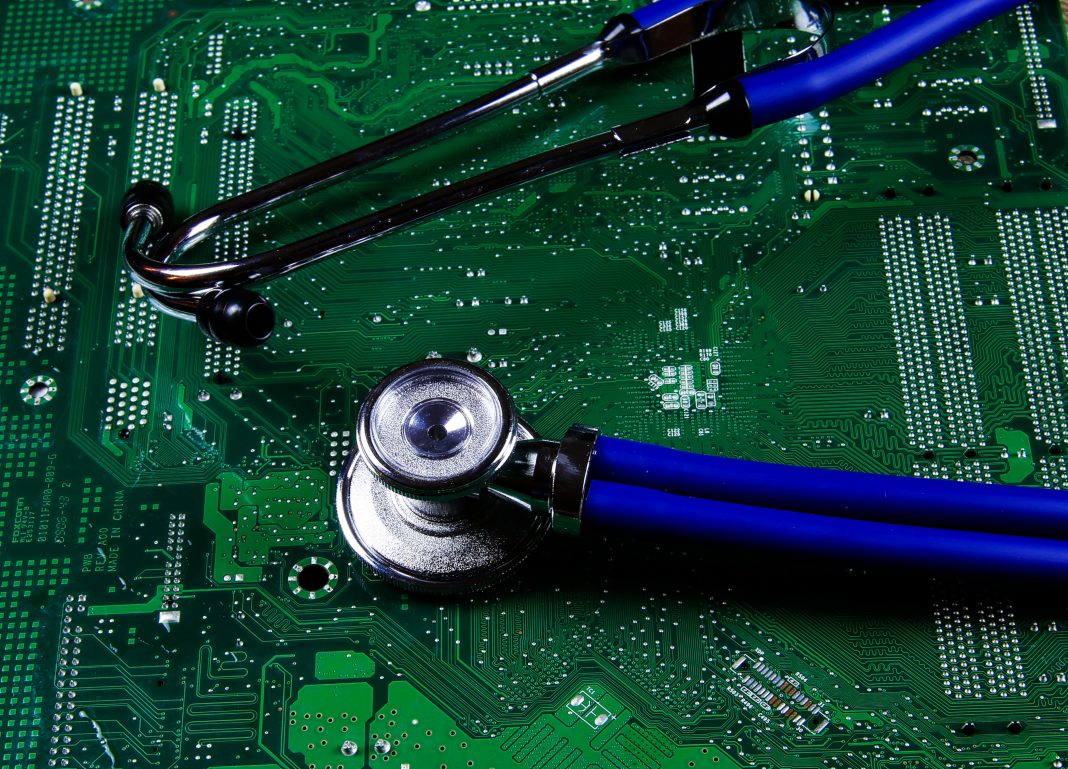 Digital health patient data storage concept - Isolated blue stethoscope on green computer circuit board