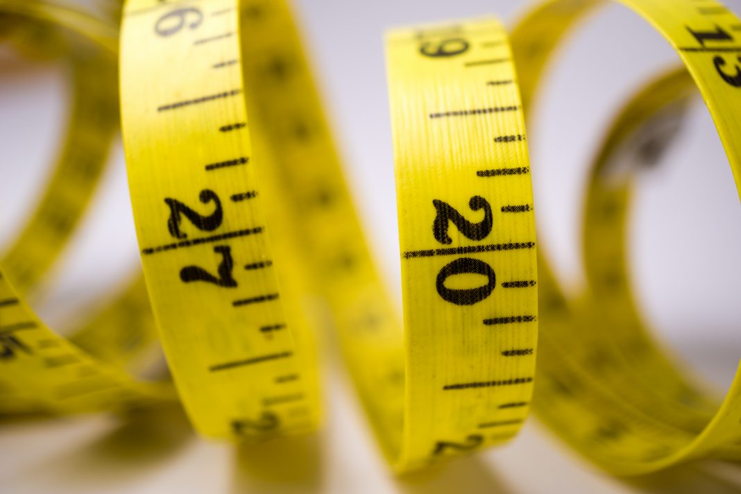 Measure tape close up view on white background fit concept overweight or obesity