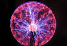 Electrical plasma ball sphere of pink and blue energy spikes, physics education
