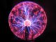 Electrical plasma ball sphere of pink and blue energy spikes, physics education