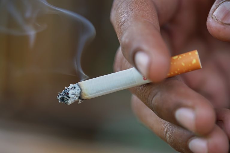 Close up man hand smoking cigarette