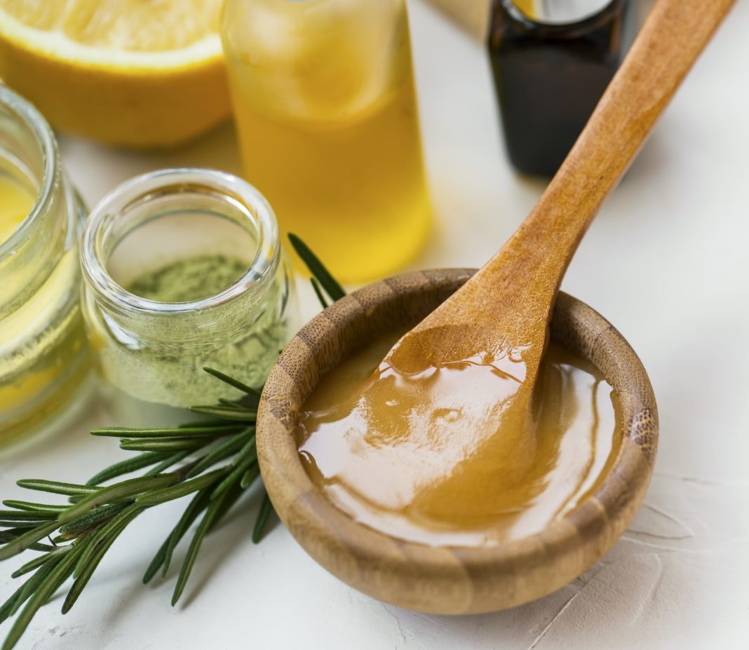 Organic skincare ingredients with manuka honey, oils, clay and rosemary herb, spa still life products honey closeup