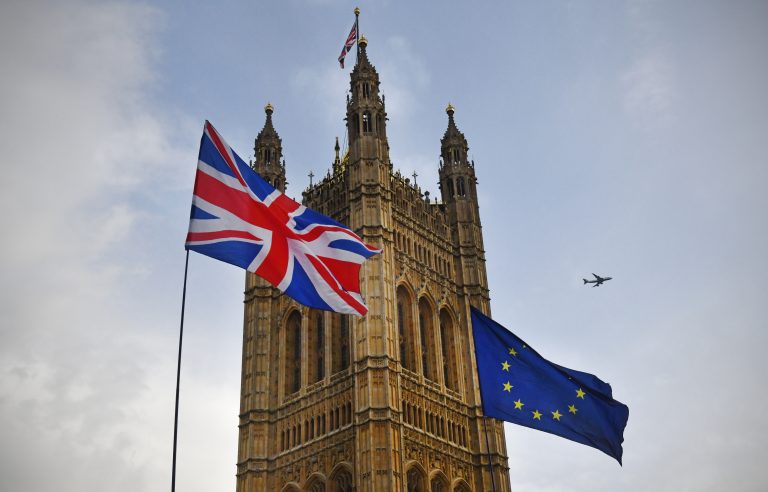 Protesters flags of United Kingdom and European Union outside Parliament in Westminster during the Brexit debates. A British Airways flight passes overhead