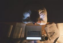 High angle shot of an unrecognizable businessman sitting alone in the office and feeling stressed while working a late night, an illustration of occupational stress