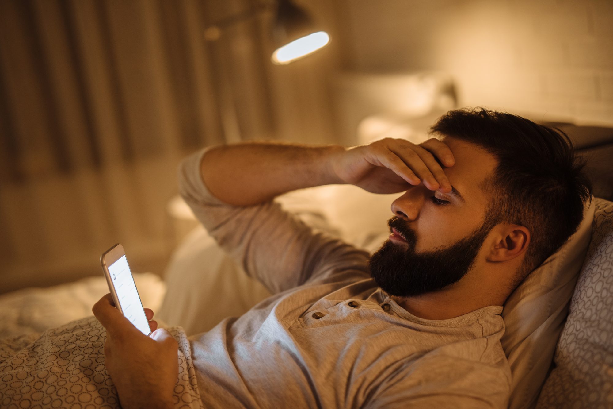 Worried young man reading bad news on smart phone,