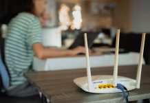 A woman is working at home using a modem router, connecting the Internet to her laptop.